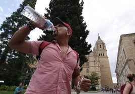 Un turista se hidrata mientras visita el casco histórico de Salamanca.