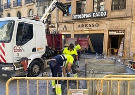 Operarios retiran las baldosas negras de pizarra para sustituirlas por otras de mayor adherencia.