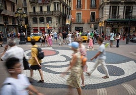 Varias personas caminan por el mosaico de Miró, en el suelo de La Rambla, escenario del atentado del 17 de agosto de 2017.
