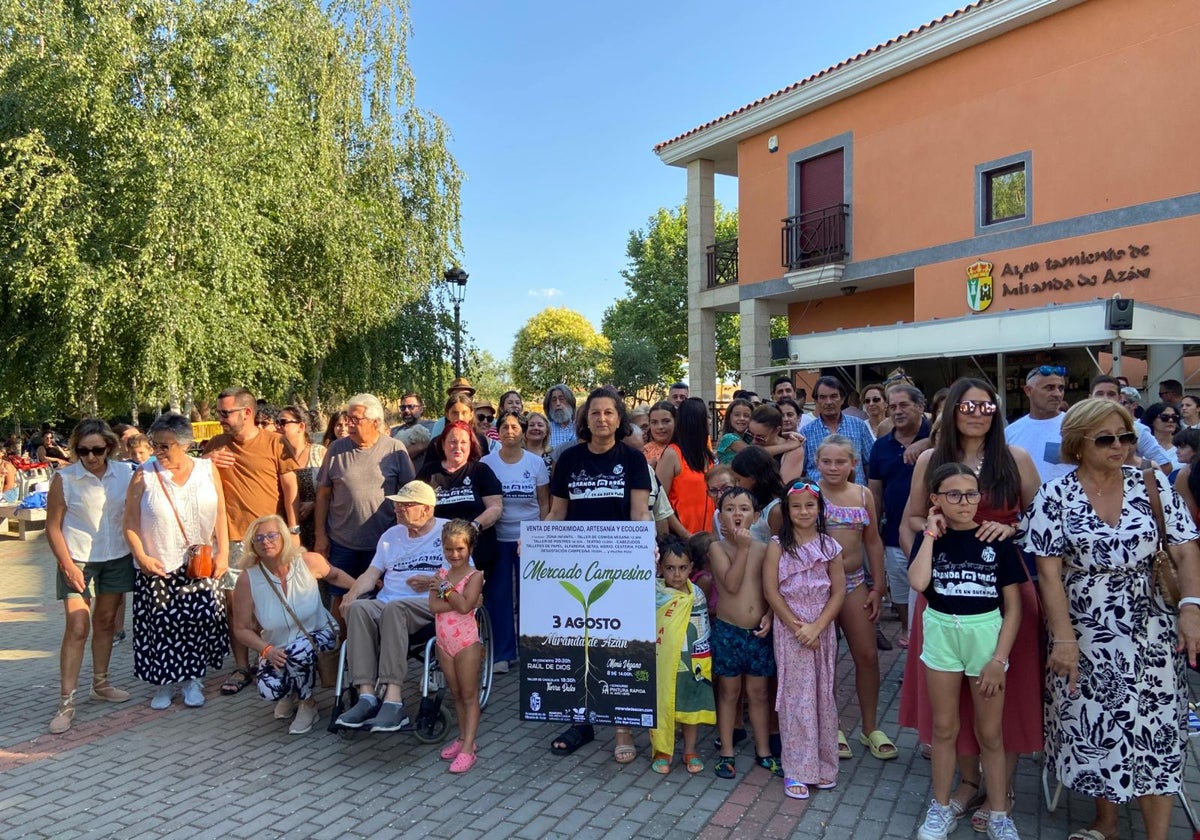 Vecinos de Miranda de Azán junto al cartel del Mercado Campesino.