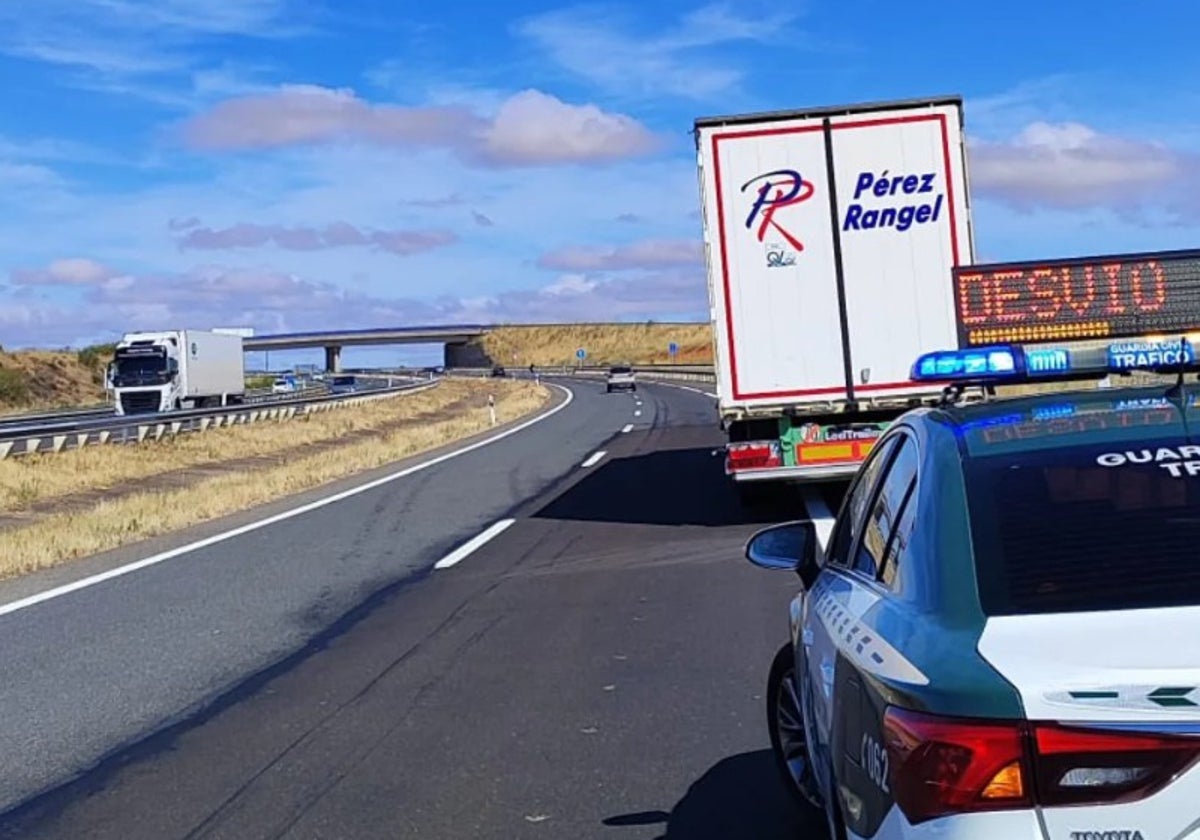 Una dotación de la Guardia Civil de Tráfico, junto al camión averiado, en la A-66.
