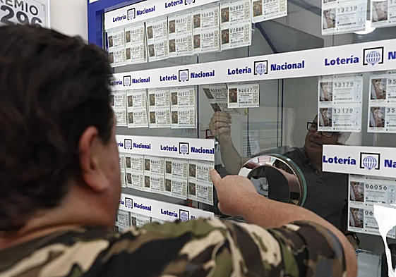 Un hombre, adquiriendo una participación de la Lotería Nacional.