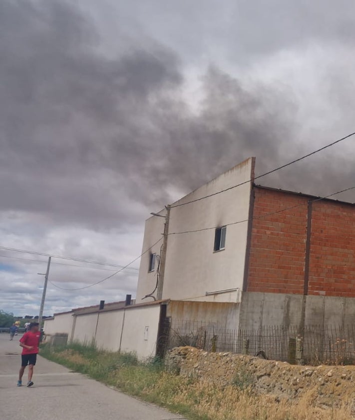 Imagen secundaria 2 - Efectivos y vecinos de la zona en el lugar del incendio de una nave en Garcihernández.