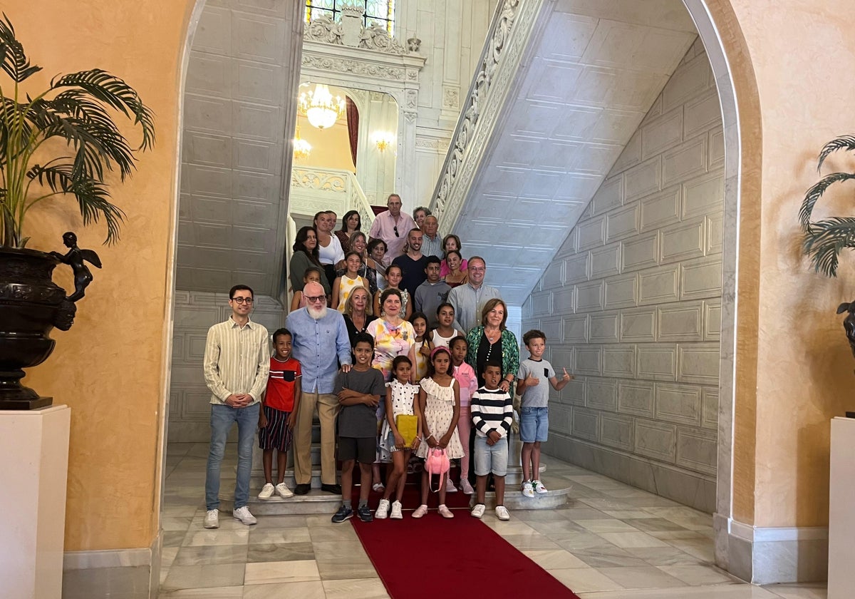 Las familias del programa «Vacaciones en Paz» junto a la corporación municipal en hall del Ayuntamiento