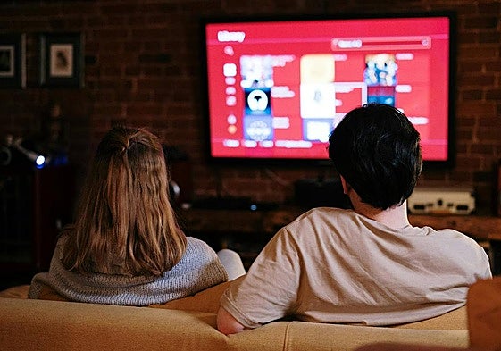 Dos personas eligiendo qué serie ver.