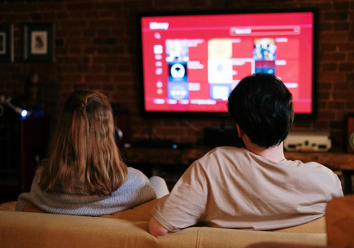 Dos personas eligiendo qué serie ver.
