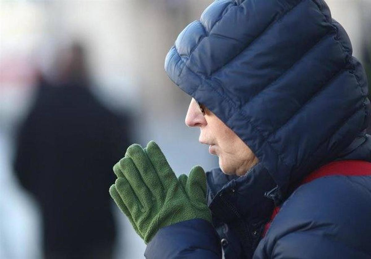 Un hombre se abriga para protegerse del frío.