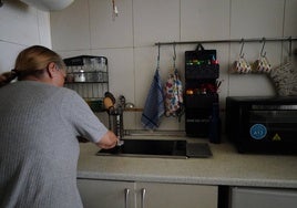 Pilar B., que prefiere ocultar su rostro, en la cocina de su pequeño apartamento.