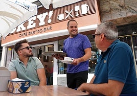 Alberto Elvira, sirviendo unos cafés a unos clientes habituales en la terraza del bar Okey.