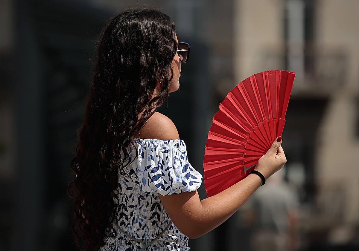 Una chica se abanica para evitar el calor.