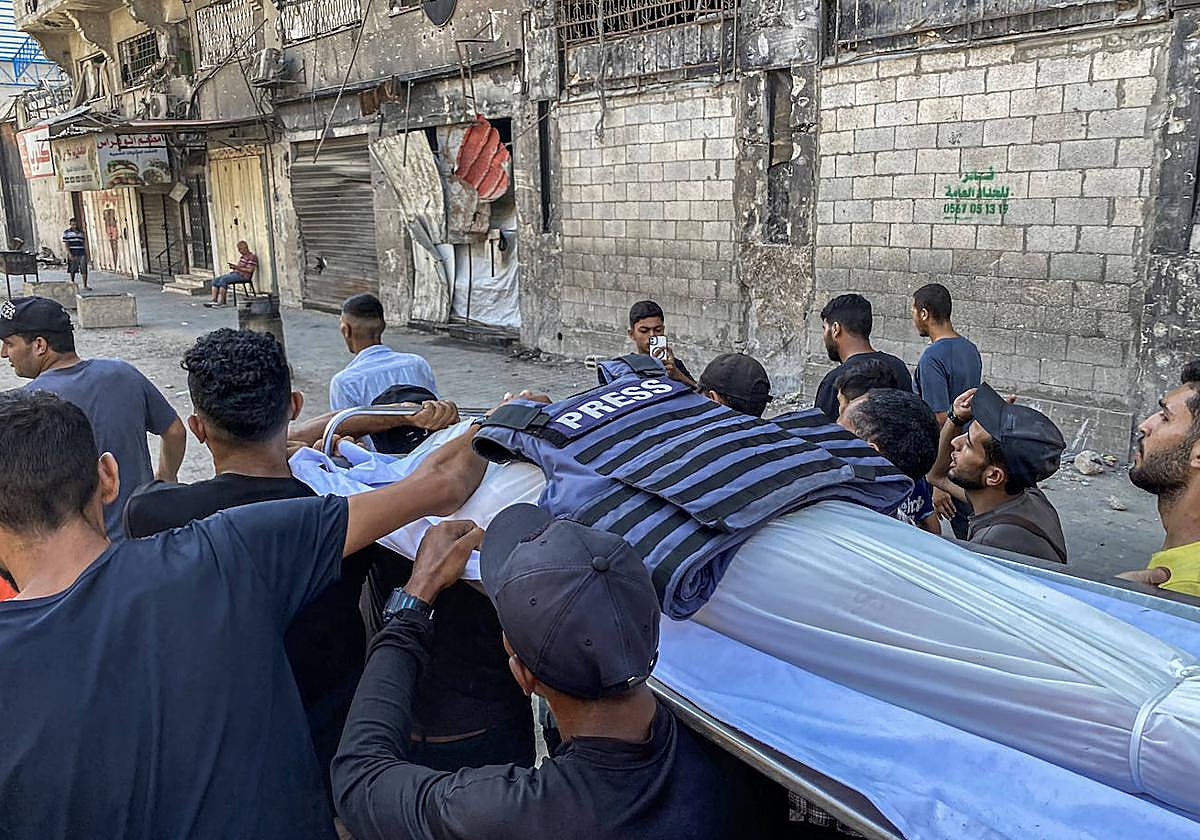 Cargan el cuerpo de un periodista muerto en Gaza.