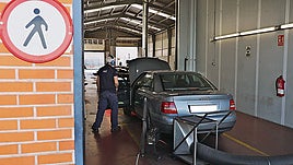 Un técnico, realizando la inspección de la ITV a uno de los vehículos.