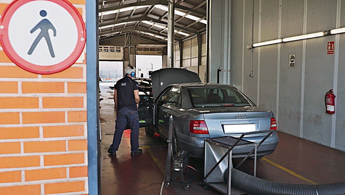 Un técnico, realizando la inspección de la ITV a uno de los vehículos.