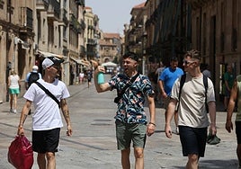 Varios viandantes se refrescaban este lunes mientras paseaban por el centro de la ciudad.