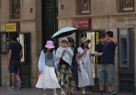 Varios turistas se protegen del calor en el centro de Salamanca.