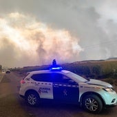 Imagen del incendio con el coche de la Guardia Civil.