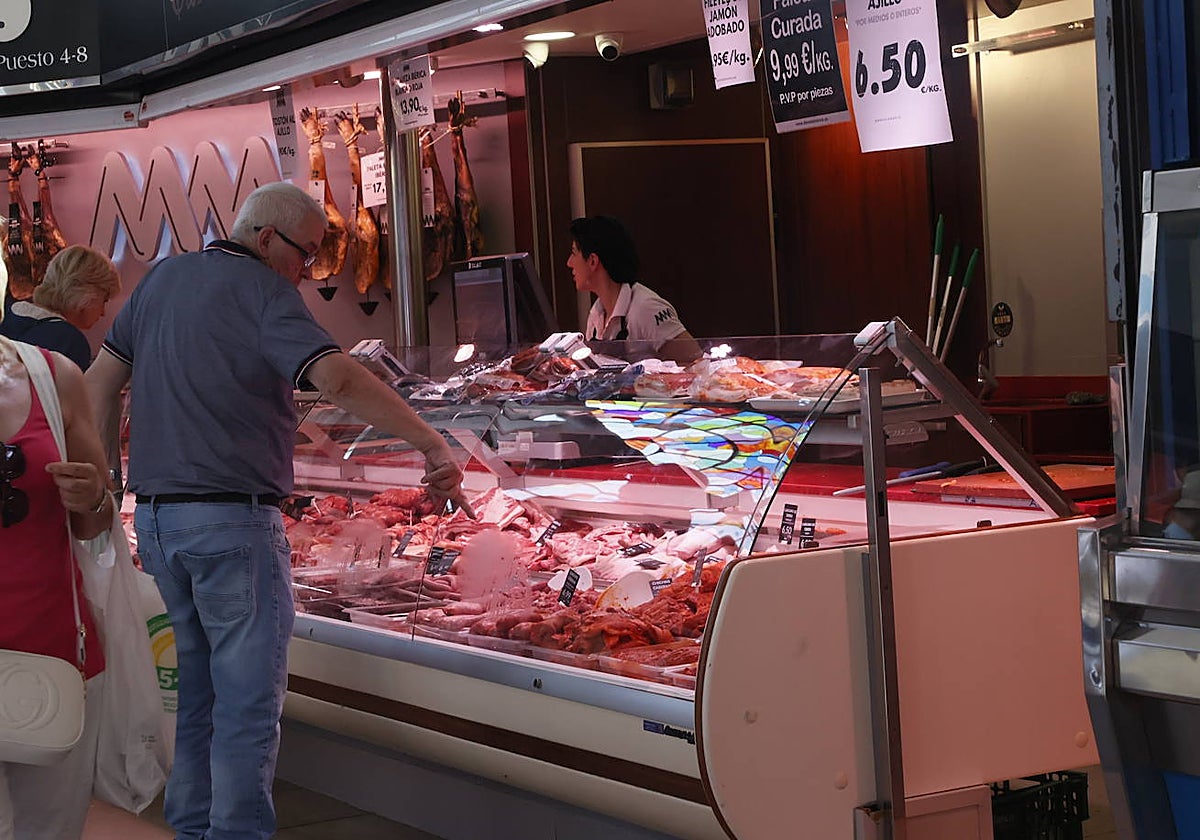 Un hombre comprando en una carnicería del Mercado Central.