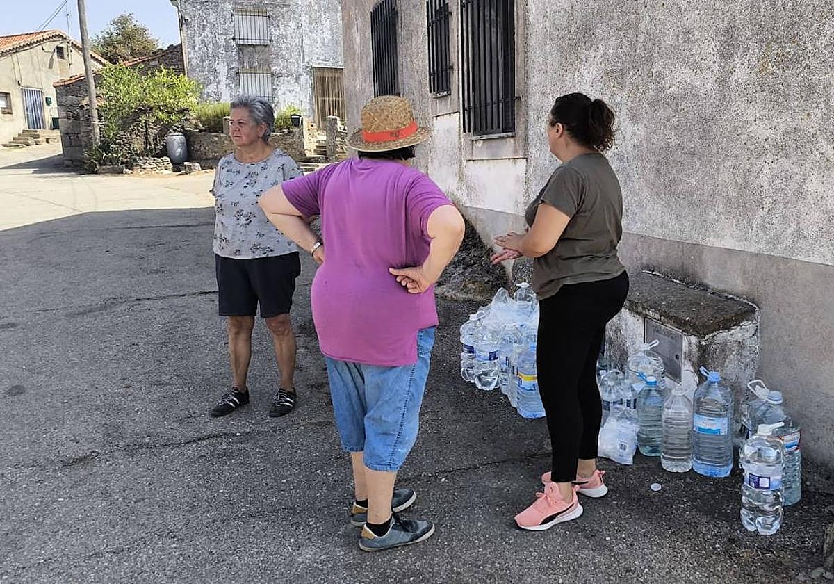 Tres vecinas de Cerezal de Puertas, con varias garrafas de agua, dispuestas a ayudar.