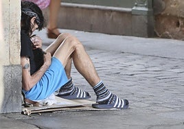 Un hombre, con su mascota, pidiendo limosna en la calle Prior.