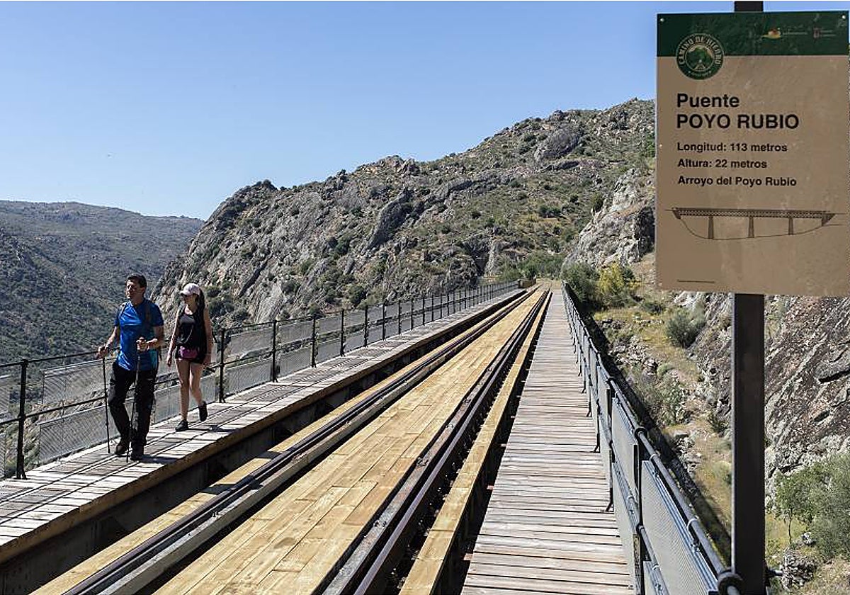 Dos senderistas, realizando la popular ruta del Camino de Hierro.