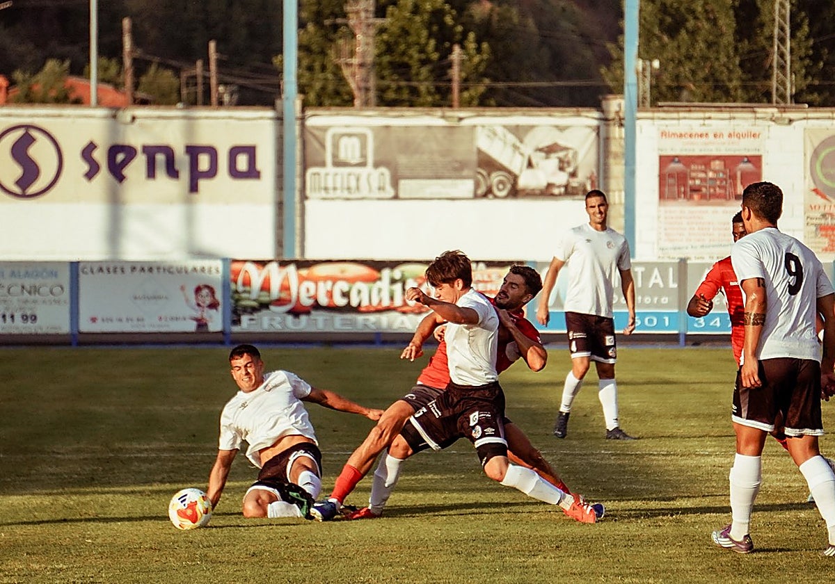 Lara y Carrasco pelean por un balón en el centro del campo.
