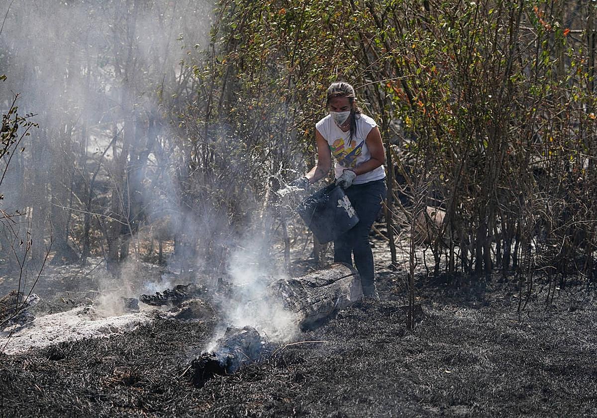 Una mujer ayuda en las labores de extinción del incendio de Cipérez.