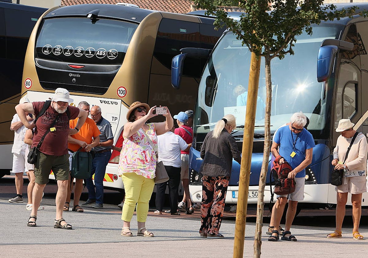 Viajeros bajando de autobuses en el centro de recepción de turistas.