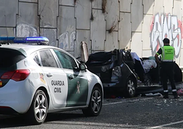 Un agente de la Guardia Civil observa el vehículo siniestrado.
