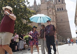 Personas protegiéndose del sol con un paraguas.