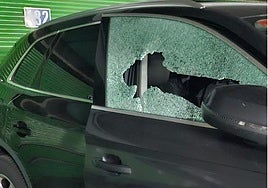 Uno de los vehículos afectados con la luna destrozada.