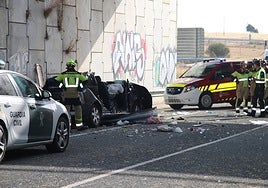 Un bombero junto al vehículo en el que circulaba la familia y que cayó por un puente.