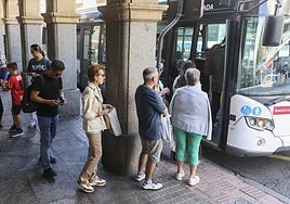 Los pasajeros del autobús metropolitano de Salamanca que hace parada en Gran Vía hacen cola para subir al transporte público.