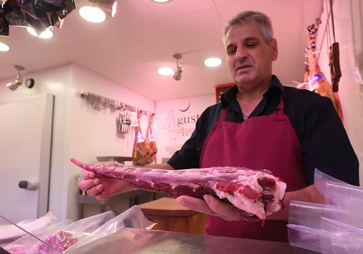 Agustín, carnicero del Mercado, cogiendo un rabo de toro.