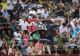 Los aficionados presentes, protegiéndose de la lluvia, en uno de los tendidos de La Glorieta.