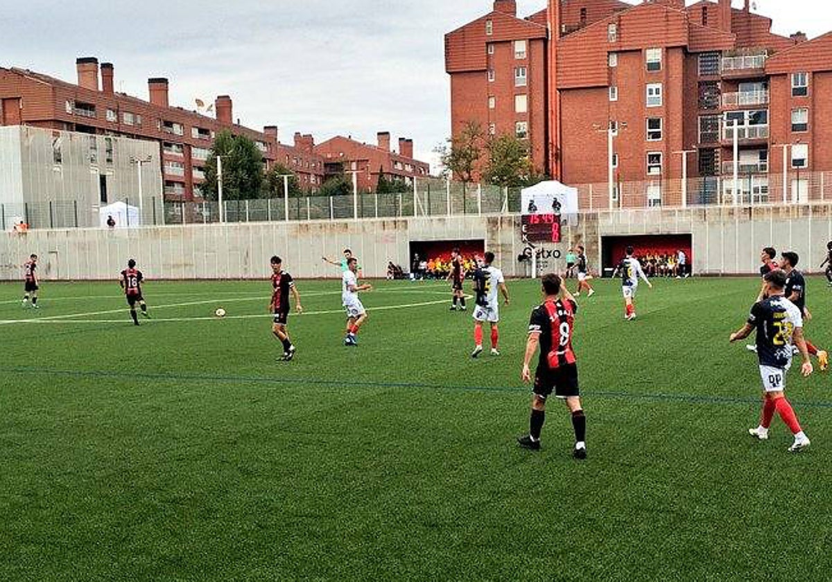 Jugadores de ambos equipos sobre el municipal de Gobela durante el encuentro.