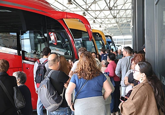 Viajeros esperando en los andenes de la estación de autobuses.
