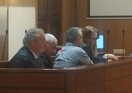 El camionero acusado, de espaldas, entre los abogados defensores.