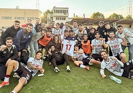 Hugo Marcos, vestido de calle a la izquierda junto a Leo Mendes, posa acompañado del resto de la plantilla acordándose de Davo tras la victoria.