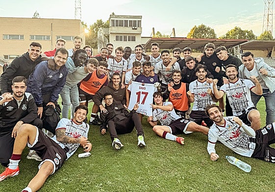Hugo Marcos, vestido de calle a la izquierda junto a Leo Mendes, posa acompañado del resto de la plantilla acordándose de Davo tras la victoria.