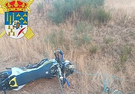 La moto de campo accidentada junto al cable en un camino en Anaya de Alba.