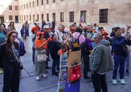 Turistas, frente a la fachada de la Universidad de Salamanca para localizar la rana.