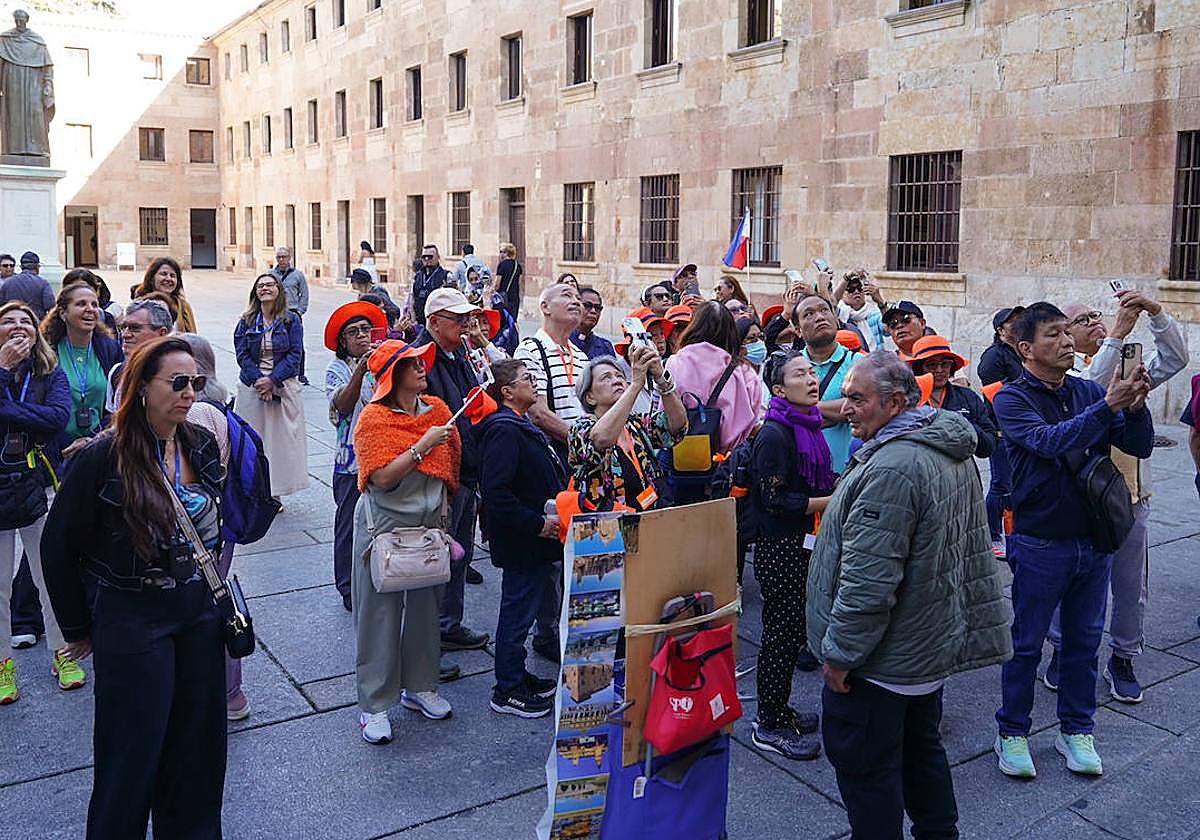 Turistas, frente a la fachada de la Universidad de Salamanca para localizar la rana.