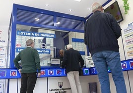 Varias personas esperan para elegir su décimo de la Lotería de Navidad.