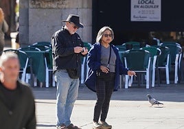 Una pareja se dispone a fumar durante un paseo por la Plaza Mayor de Salamanca.