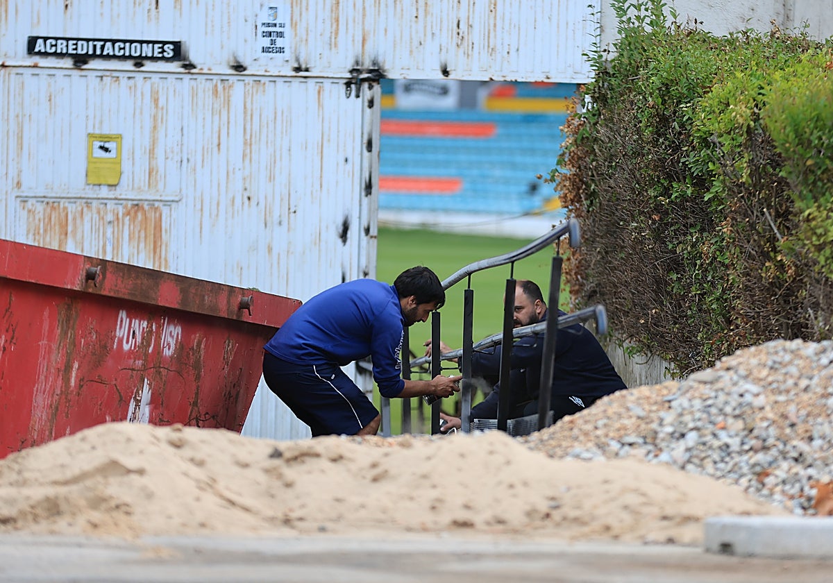 Manuel Vicente y Óscar Albo pintando el nuevo pasamanos de la puerta de acreditaciones.