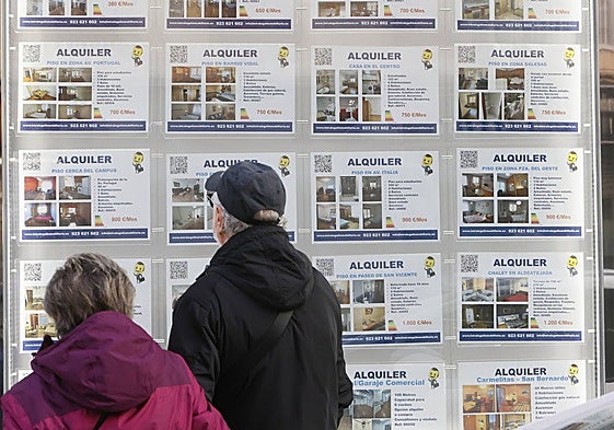 Una pareja mira los anuncios de alquiler de una inmobiliaria.