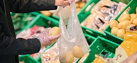 Una clienta compra unas patatas en una tienda de Mercadona.