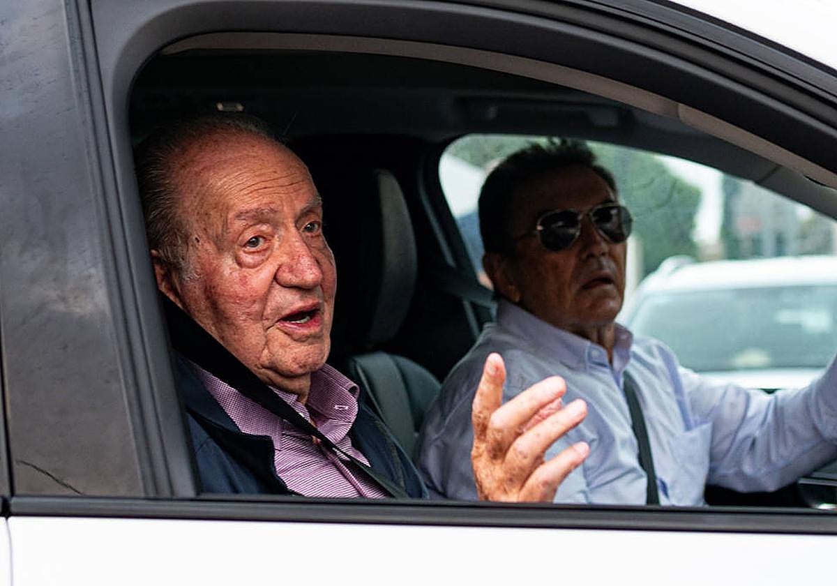 El rey Juan Carlos saluda a su salida en un coche.