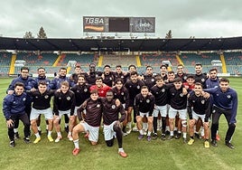Jugadores y técnicos del Salamanca UDS, sonrientes sobre el césped del Helmántico.