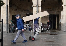 Dos trabajadores por la plaza del Mercado.